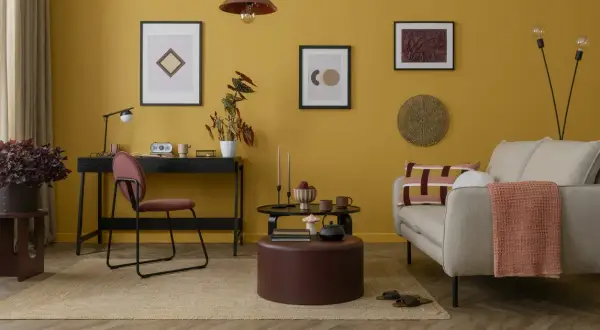 Un soggiorno con pareti color ocra e arredi che creano abbinamenti caldi e accoglienti.