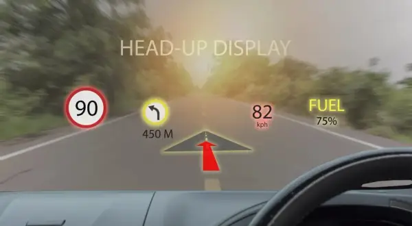 Head-up display cos'è: informazioni di guida proiettate sul parabrezza: limite 90, svolta a 450m, velocità 82 km/h, carburante 75%.