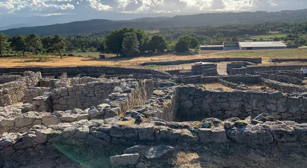 Ruinas de piedra en San Amaro, Ourense, bajo un cielo nublado y sol radiante.
