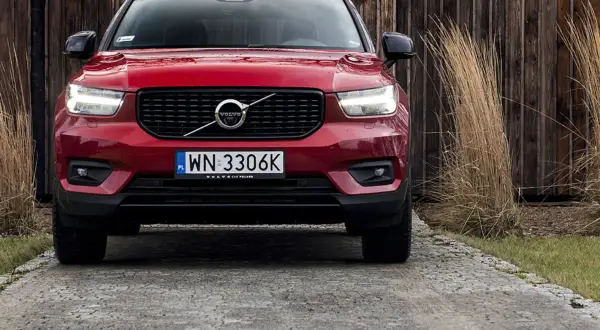 Czerwone Volvo XC40 na podjeździe. Zbliżenie na przód auta, gdzie widoczne są światła, grill i tablica rejestracyjna. Poznaj volvo xc40 wymiary.