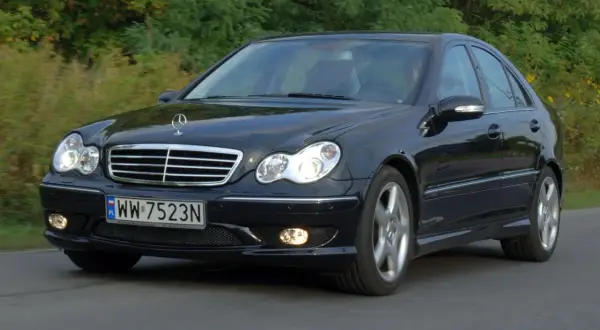 Czarny Mercedes W203 1.8 Kompressor w ruchu, z widocznym grillem i reflektorami.