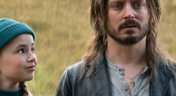 Elijah Wood w filmach, w tym w tym kadrze, gdzie towarzyszy mu młoda dziewczyna.