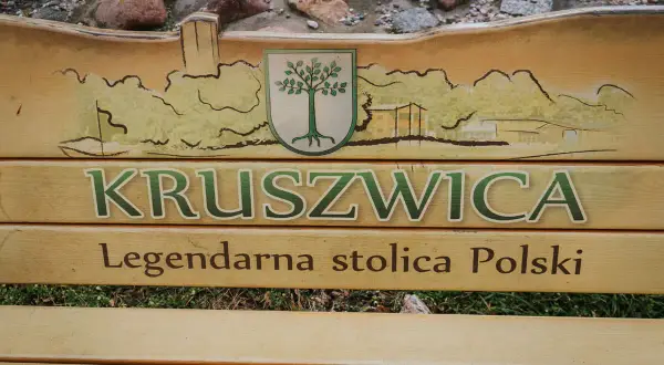 Drewniana ławka z napisem "Kruszwica Legendarna stolica Polski" i malowidłem nawiązującym do szlaku piastowskiego.