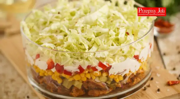 Warstwowa sałatka gyros z mięsem mielonym, kukurydzą, papryką i chrupiącą kapustą pekińską w szklanej misie.
