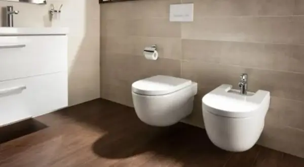 Nowoczesna łazienka z wiszącym wc i bidetem. Jest sporo miejsca na swobodne poruszanie się.