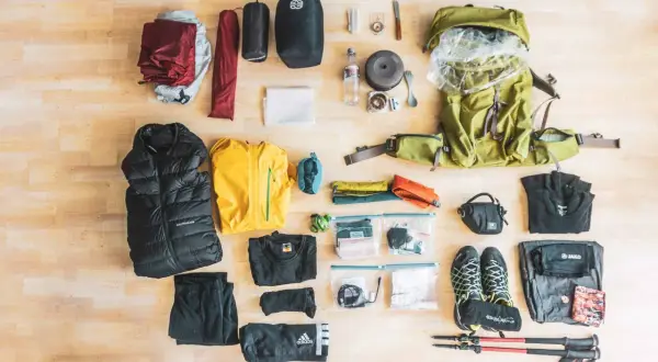 Alles für eine Trekking-Tour: Rucksack, Zelt, Schlafsack, Kleidung, Schuhe, Kochutensilien und Wanderstöcke.