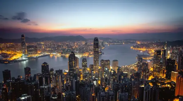Wieczorny widok na rozświetlony Hongkong. Wiele wieżowców lśni światłami, tworząc niesamowity krajobraz. Ciekawe fakty o tym mieście można odkrywać, podziwiając jego panoramę.