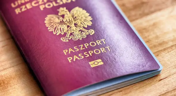 Polski paszport biometryczny z godłem orła i napisem "PASZPORT PASSPORT" na bordowej okładce.
