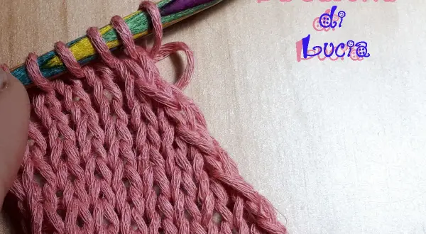 Uncinetto su ferri colorati, un lavoro a maglia rosa che ricorda un baktus.