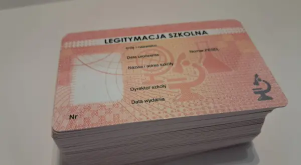 Stos nowych legitymacji szkolnych, gotowych do wypełnienia. Każda zawiera pole na numer legitymacji szkolnej, dane ucznia i szkoły.
