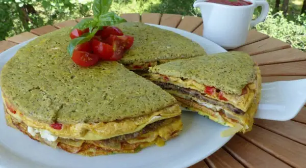 Le crespeou, une tourte verte aux couches d'omelette et de légumes, garnie de tomates et de basilic.