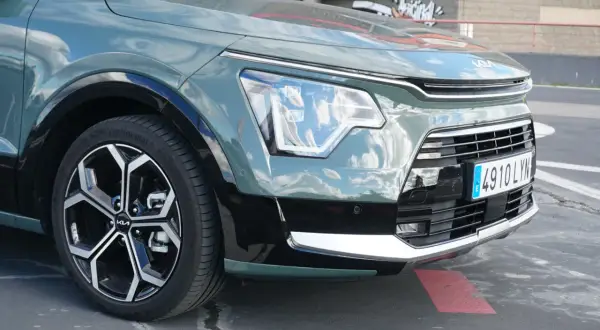 Detaljer från en kia niro hybrid test: framhjul, strålkastare och grill.