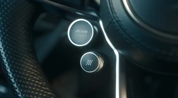 Przycisk "drive select" i przycisk z szachownicą, gotowe do aktywacji launch control.