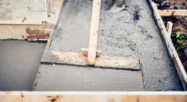 Wylewanie świeżego betonu B20 w szalunku. Sprawdzamy, czy beton b20 cena za m3 jest korzystna, by dokończyć prace.