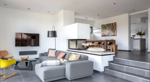 Modernes split-level Haus mit offenem Wohnbereich, Kamin, Essbereich und stilvoller Einrichtung.