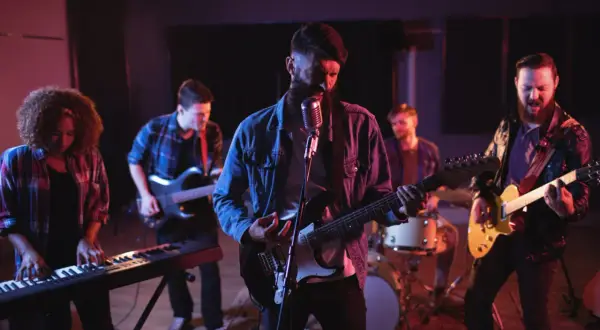 Zespół rockowy grający na gitarach, klawiszach i perkusji w studiu nagraniowym.