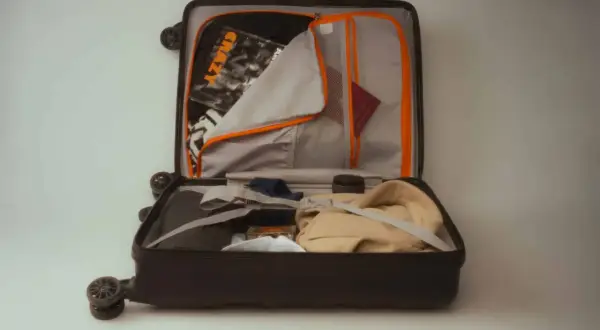 Otwarta walizka 10 kg Ryanair, gotowa na podróż. W środku ubrania, paszport i kosmetyki.