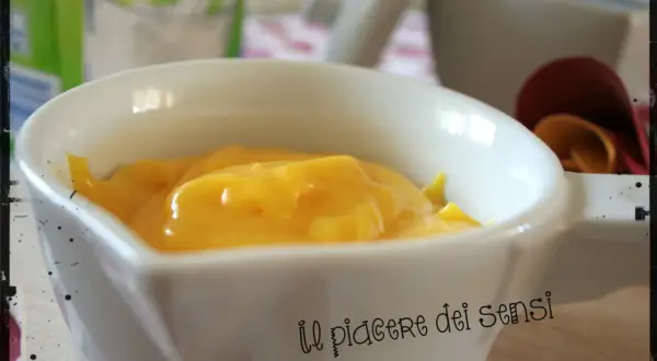 Crema pasticcera ricetta della nonna, densa e dorata, in una ciotola bianca. Un piacere per gli occhi e per il palato.
