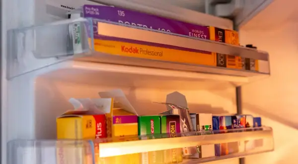 A collection of 35mm film rolls, including Kodak Portra 400 and Kodak Professional, stored in a refrigerator. These films are perfect for achieving that best 35mm film for vintage look.