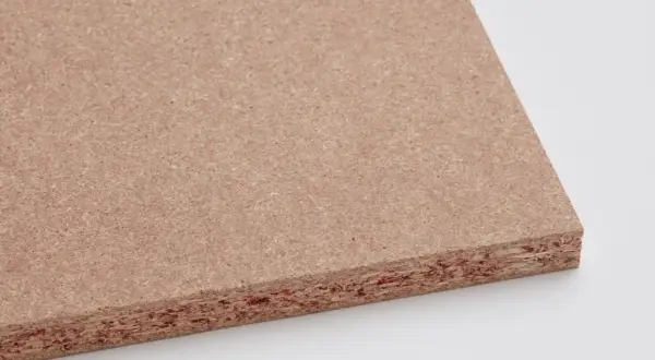 Placa de maderas artificiales con textura granular y capas visibles. Ideal para proyectos de construcción y mobiliario.