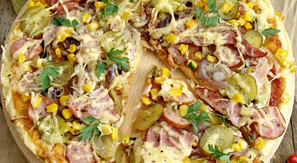 Pizza wiejska składniki: ser, kukurydza, ogórek kiszony, cebula, kiełbasa, szynka, natka pietruszki. Apetyczny widok!