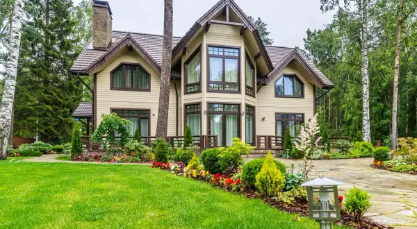 Elegantes casas canadienses rodeadas de exuberante vegetación y un jardín cuidado.