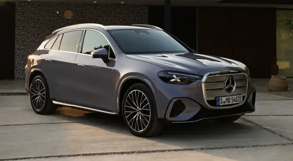 Un elegante GLC eléctrico 2026 gris metálico, con diseño moderno y llantas deportivas, estacionado en una entrada de concreto.