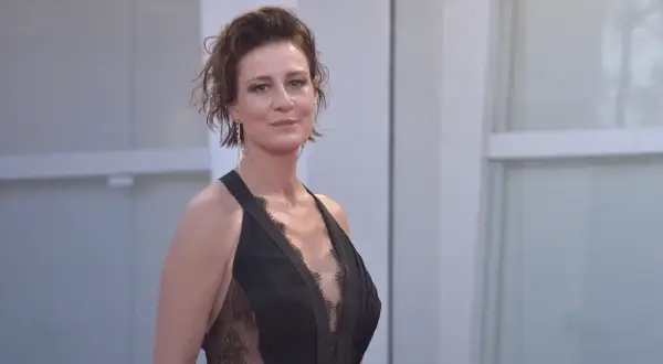 Maja Ostaszewska w czarnej, koronkowej sukni na czerwonym dywanie. Aktorka znana z wielu polskich filmów.