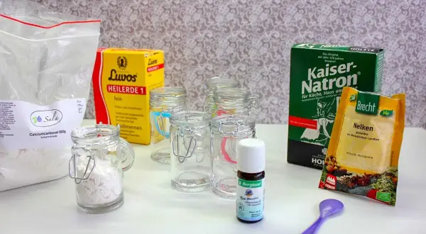Zutaten für zahnputzpulver selber machen: Calciumcarbonat, Kaiser-Natron, Luvos Heilerde, Nelken und ätherisches Öl in kleinen Gläsern.