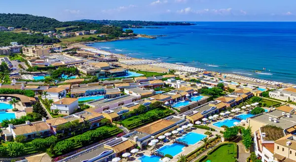 Idealne wakacje na Peloponezie: rozległy kompleks hotelowy z basenami i plażą nad turkusowym morzem.