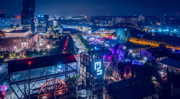 Nocny festiwal Tauron Nowa Muzyka w Katowicach. Widać sceny, tłumy ludzi i charakterystyczne budynki postindustrialne.