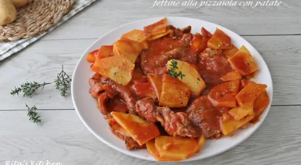 Piatto di fettine di carne in salsa pizzaiola con patate a fette, guarnito con timo fresco.