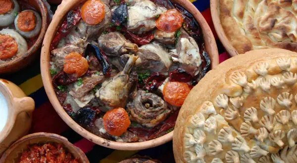 Bogactwo smaków kuchni bałkańskiej: pieczone mięso z ryżem, faszerowane cebule, chleb z ozdobami i ajvar.