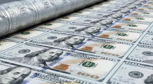 Druk banknotów 100 dolarowych na maszynie drukarskiej.