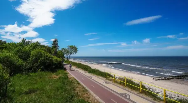 Ścieżka rowerowa wzdłuż plaży Morza Bałtyckiego. Ciekawostki o Bałtyku? Tu można podziwiać fale i poczuć morską bryzę.