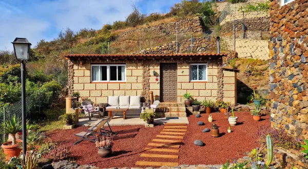 Acogedora casa rural de piedra, rodeada de plantas y con un camino de madera que lleva a la entrada. Un lugar perfecto para disfrutar de la tranquilidad de el escobonal.