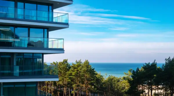 Nowoczesny budynek z balkonami i widokiem na morze. Wiele osób szuka wave międzyzdroje resort&spa opinie, by sprawdzić jakość wypoczynku.