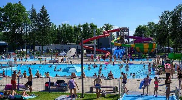 Tarnów atrakcje dla dzieci: wodny plac zabaw z basenami i zjeżdżalniami, gdzie bawią się tłumy ludzi w słoneczny dzień.
