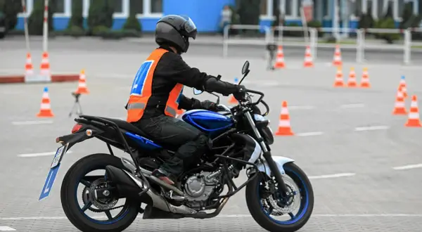 Motocyklista na placu manewrowym, przygotowuje się do egzaminu. Sprawdza, jaka jest prawo jazdy a2 cena, by móc legalnie jeździć.