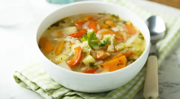 Aromaticzny kapuśniak ze słodkiej kapusty z marchewką i ziemniakami, udekorowany natką pietruszki. Idealny na chłodne dni.