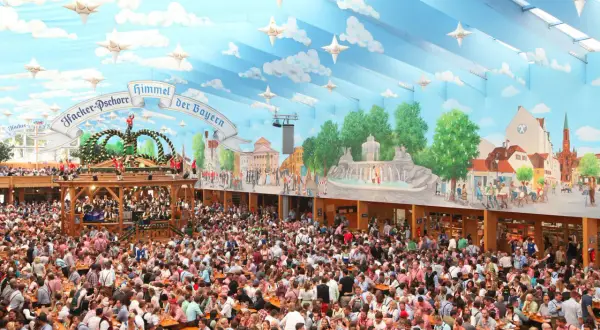 Folla festante in una tenda decorata con cielo azzurro e nuvole, un'autentica scena delle **tedesche Oktoberfest**.
