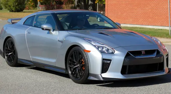 Srebrny Nissan GTR z pomarańczowymi zaciskami hamulcowymi, gotowy do jazdy.