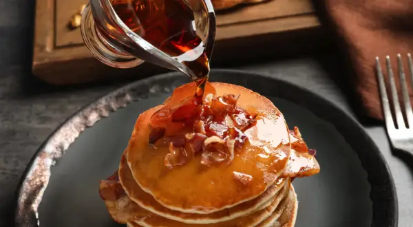 Pancakes con sciroppo d'acero e bacon. Meglio sciroppo d'acero o agave? La scelta è tua per questa delizia.