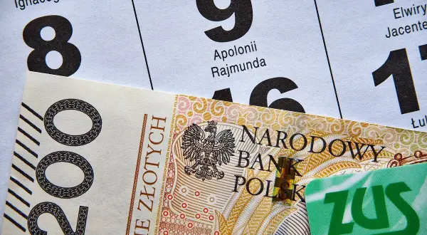 200 zł i zielona karta ZUS na tle kalendarza. Czekasz na przelew, kiedy ZUS robi przelewy?