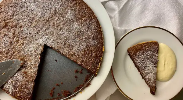 Chokladkaka med pudersocker, en bit serverad med grädde. Perfekt för att baka snabbt och enkelt.