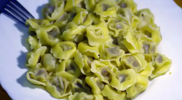 Porcja tortellini na talerzu, gotowa do jedzenia. Zastanawiasz się, ile gotuje się makaron tego typu?