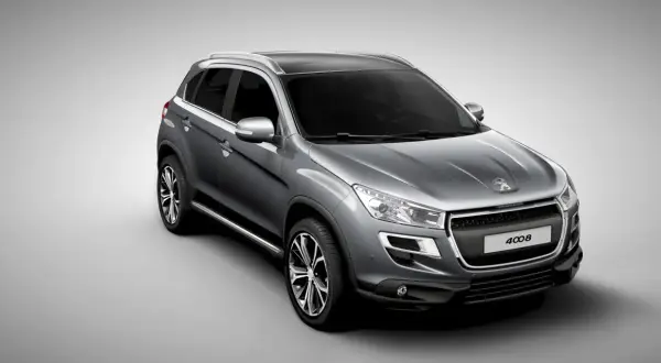 Szary crossover Peugeot 4008 z czarnym dachem i srebrnymi relingami, widok z przodu i z boku.