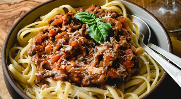 Ein Teller Spaghetti mit herzhafter Bolognese-Sauce, garniert mit Basilikum und Parmesan. Perfekt für ein klassisches bolognese rezept.