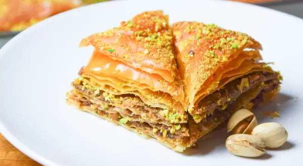 Słynna baklava co to? Warstwowe ciasto filo z orzechami i syropem, posypane pistacjami. Pyszny deser.