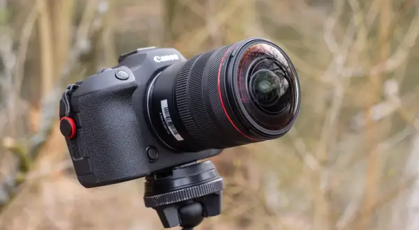 Obiektyw Canon z soczewką przypominającą rybie oczy, zamontowany na statywie, gotowy do uchwycenia świata w szerokim kadrze.